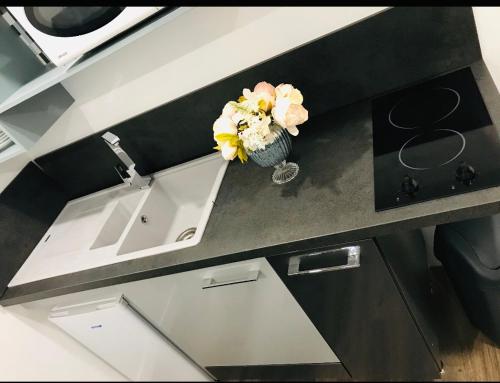 un vaso di fiori seduto su un bancone della cucina di L'ECRIN - Proche de RENNES - Lumineux - Au Calme a Liffré
