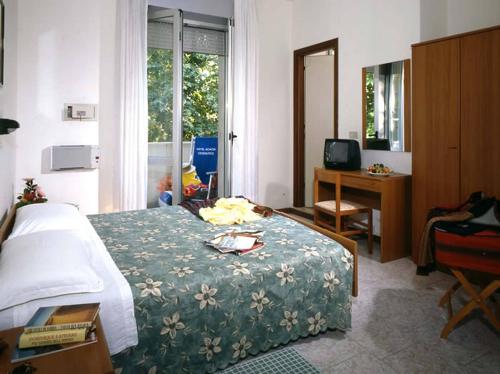 チェゼナーティコにあるHotel Acaciaのベッドルーム1室(ベッド1台、デスク、窓付)