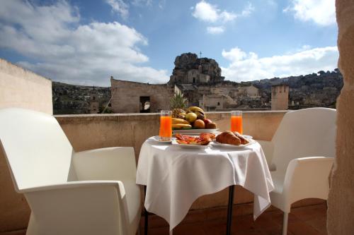 a table with a bowl of fruit and a view of a castle at Caveoso Hotel in Matera