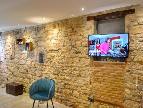a wall with a tv on a stone wall at STUDIO APARTMAN ELEVEN in Rovinj