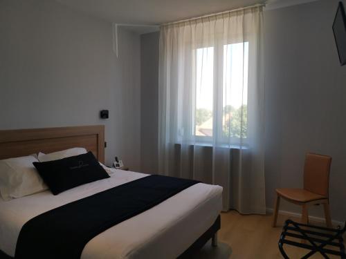 Chazelles-sur-LyonにあるChâteau Blanchardのベッドルーム1室(窓、ベッド1台、椅子付)