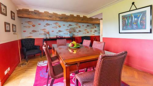 a dining room with a wooden table and chairs at Le Clos Tellier in Mareil-Marly