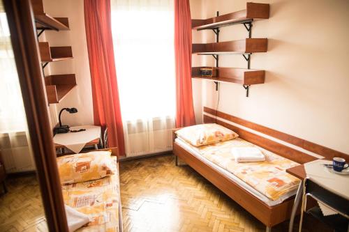 a small room with two beds and a window at Żaczek Hotele Studenckie in Krakow