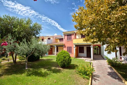 a house with a yard with trees and a pathway at L'Oasi di Ottiolu in Porto Ottiolu