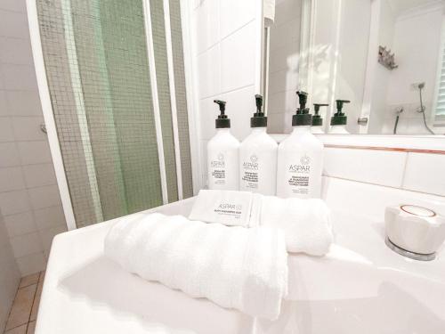 ein Badezimmer mit 3 Flaschen Toilettenpapier auf einem Waschbecken in der Unterkunft Frangipani Cottage in North Haven