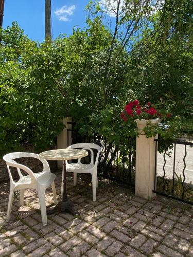 a table and two chairs sitting next to a fence at Les Merisiers B&B - Thorenc in Thorenc