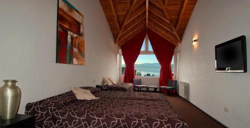 um quarto com uma cama e uma grande janela em Hotel Kilton em San Carlos de Bariloche