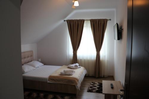 Habitación pequeña con cama y ventana en Casa Coman Moisei, en Moisei