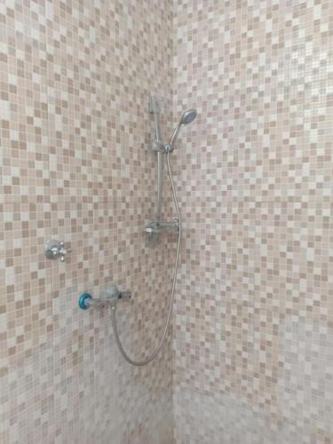 a shower with a hose in a bathroom at Hotel Mutiara Baru in Batu