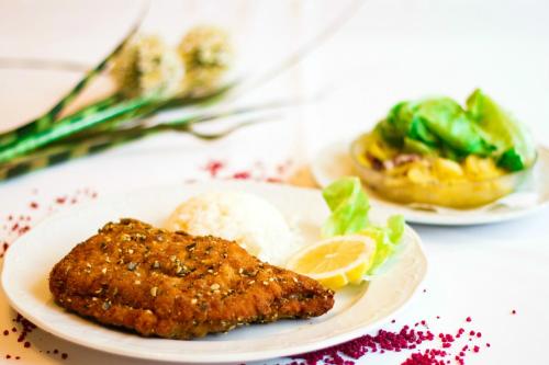 a plate of food with a piece of fish and rice at Gasthof Familie Hutter in Rattersdorf