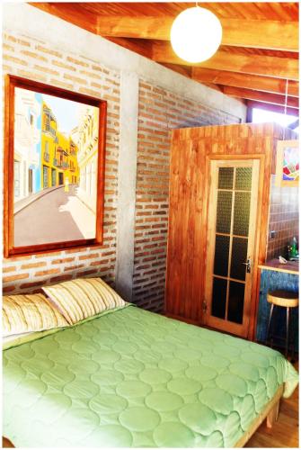 a bedroom with a large bed in a brick wall at Cabañas La Magia de Isla Negra in Isla Negra