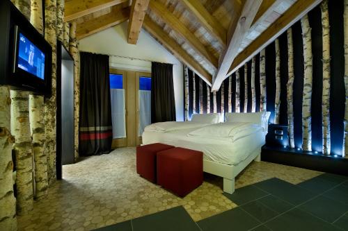 a bedroom with a bed and a tv in it at Alpen Hotel Chalet in Valdidentro