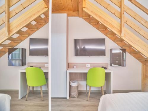 a room with a desk and two green chairs at Hotel Medusa in Finale Ligure