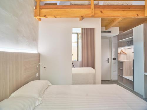 a bedroom with a white bed and a room with a bed at Hotel Medusa in Finale Ligure