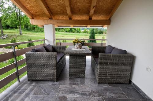a patio with wicker chairs and a table on a deck at Studio apartments Kaya in Čatrnja