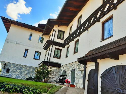 a large white house with a gate in front of it at Hotel/Pension Rosengarten in Franking