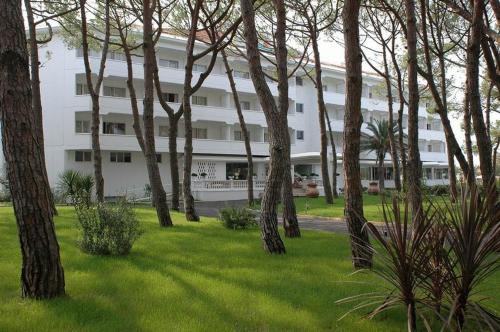 a large white building with trees in front of it at Domizia Palace Hotel in Baia Domizia