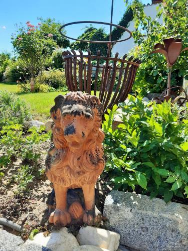 a statue of a lion standing in a garden at Hotel/Pension Rosengarten in Franking