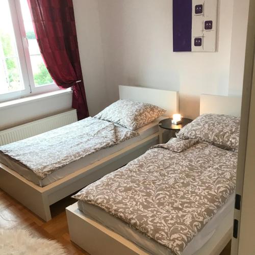 two beds in a small room with a window at LG living Apartment in Stockerau