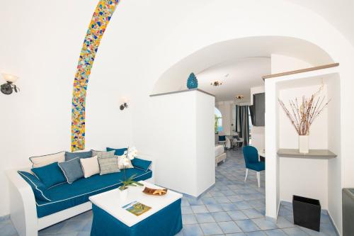 uma sala de estar com um sofá azul e uma mesa em Positano Art Hotel Pasitea em Positano