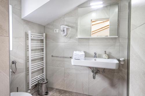 a white bathroom with a sink and a shower at Studio apartments Kaya in Čatrnja