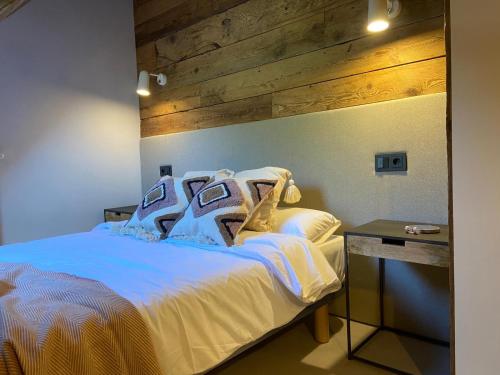 a bedroom with a white bed with a wooden wall at BARN THE RETREAT Bonito dúplex en Vielha in Vielha