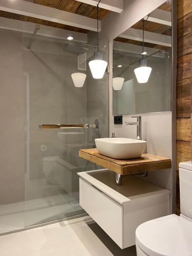 a bathroom with a sink and a glass shower at Bonito dúplex en Vielha in Vielha