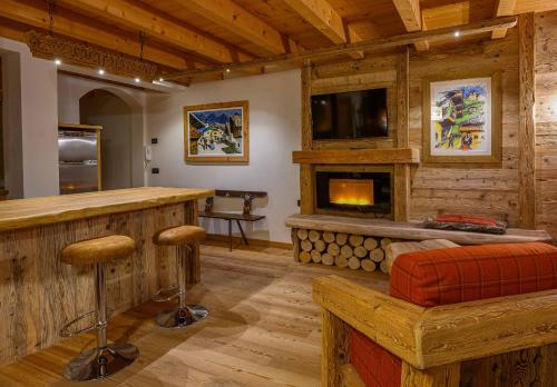 a living room with a bar and a fireplace at Ciandolada Wellness in Vodo Cadore