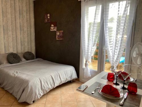 um quarto com uma cama, uma mesa e uma janela em studio indépendant dans villa avec piscine jacuzzi em Vidauban