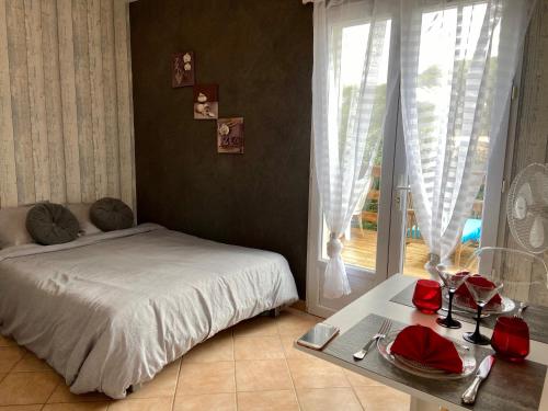 une chambre avec un lit, une table et une fenêtre dans l'établissement studio indépendant dans villa avec piscine jacuzzi, à Vidauban