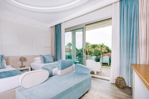 a bedroom with two beds and a balcony at Ilica Hotel Spa & Wellness Resort in Çeşme