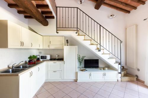 a kitchen with white cabinets and a staircase at Borgo Verde in Vada