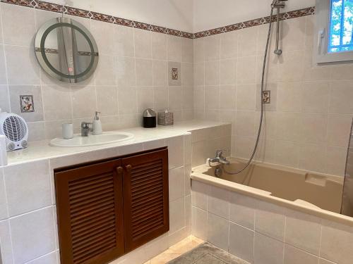 uma casa de banho com um lavatório, um chuveiro e uma banheira em studio indépendant dans villa avec piscine jacuzzi em Vidauban