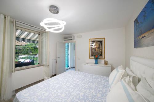 a white bedroom with a bed and a window at Zaffiro house in Minori