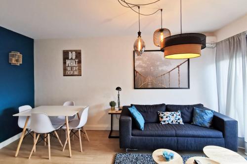 un salon avec un canapé bleu et une table dans l'établissement Charming Apartment In The Centre Of Lyon, à Lyon