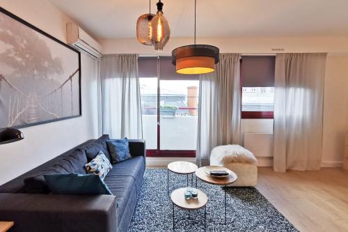 un salon avec un canapé et deux tables dans l'établissement Charming Apartment In The Centre Of Lyon, à Lyon