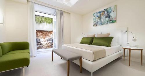 a bedroom with a bed and a chair and a window at Hotel Villa Blu Capri in Anacapri