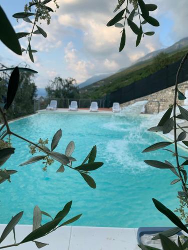 ein Pool mit blauem Wasser und Bergen im Hintergrund in der Unterkunft Agricampeggio Paradiso in Brenzone sul Garda