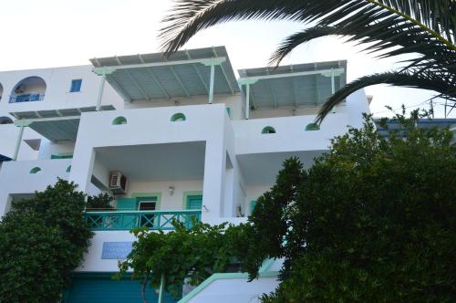 a white building with trees in front of it at The Anafians Studios in Anafi