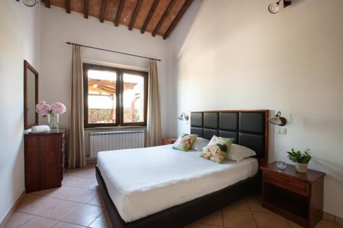 a bedroom with a large white bed and a window at Borgo Verde in Vada
