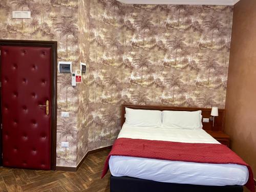 a bedroom with a bed and a wallpaper with palm trees at Villa Pallotta Luxury B&B in Cerignola