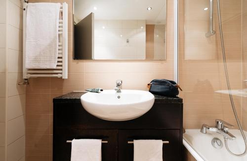 a bathroom with a white sink and a mirror at Hotel la Brunerie in Les Deux Alpes