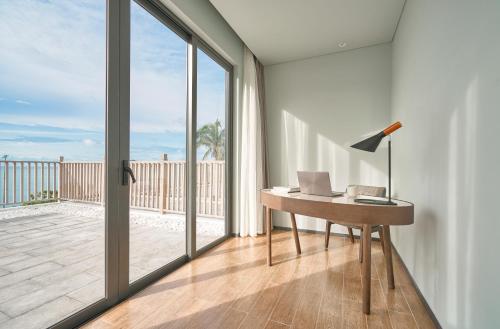 an office with a desk with a laptop and a balcony at The Secret Con Dao in Con Dao