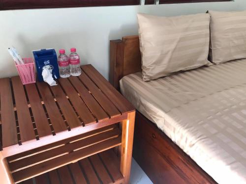 Un dormitorio con una cama y un banco con botellas de agua. en Manel Guesthouse and Restaurant, en Sen Monorom