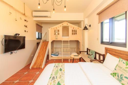 a small room with a bed and a play house at 新斑鳩小鎮親子民宿 10-28人可來電包棟 in Wujie