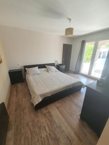 1 dormitorio con 1 cama y suelo de madera en Hacienda Shelsy en Magalas