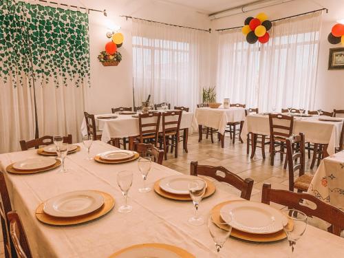 un comedor con mesas y sillas con platos y copas de vino en Agriturismo Baccole, en Gagliano del Capo