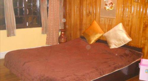 - un lit avec 2 oreillers dans une chambre dans l'établissement Tip Top Gujarati House, à Gangtok