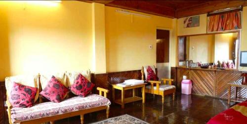 - un salon avec un canapé et une table dans l'établissement Tip Top Gujarati House, à Gangtok