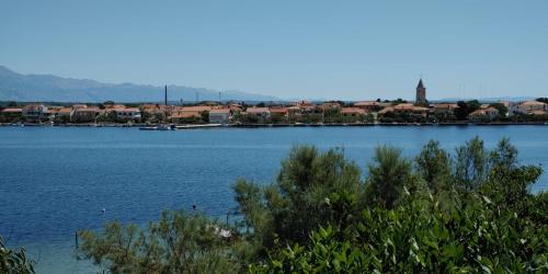 een grote hoeveelheid water met een stad op de achtergrond bij Seaview Holiday Apartments, Ventura Nin in Nin